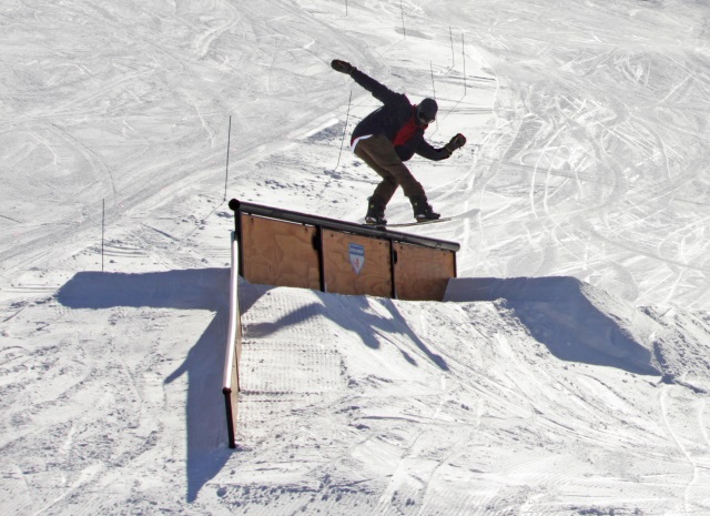 Snowboarder sending a sick trick off a large jump.